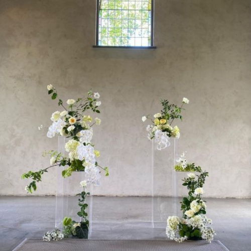 greenery and florals on clear pedestals