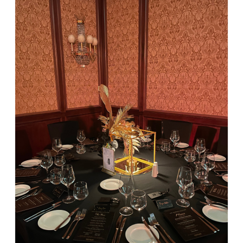 uxury table centrepiece with black florals, gold palm leaves and elegant event décor for gala events.
