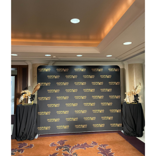 Abstract Golden Floral Feature with black florals, gold palm leaves and elegant event styling framing a luxury corporate media wall backdrop.
