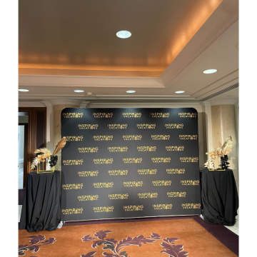 Abstract Golden Floral Feature with black florals, gold palm leaves and elegant event styling framing a luxury corporate media wall backdrop.