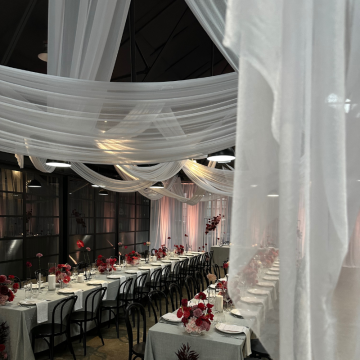 white chiffon drape over beams in barn wedding