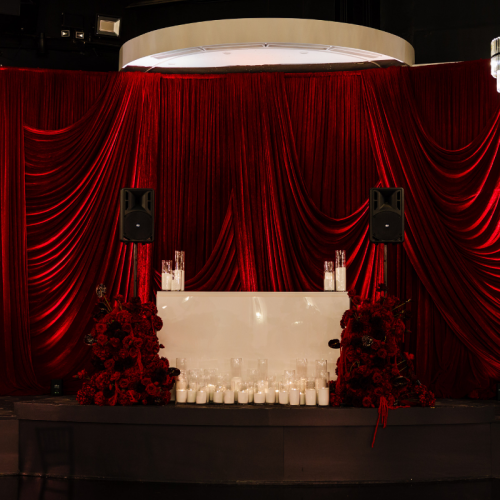 dj booth with deep red velvet draped backdrop