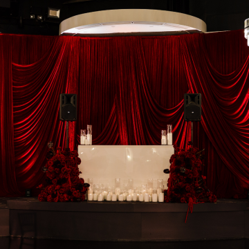 dj booth with deep red velvet draped backdrop