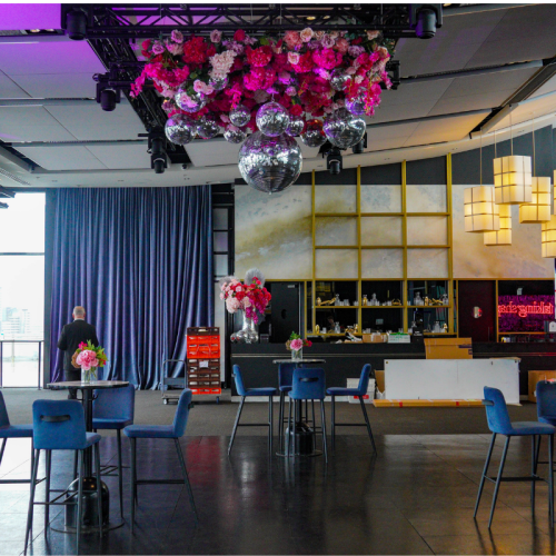 Fuchsia Fever Floral Feature styled with hanging disco florals, mirror balls, pink flowers and faux florals, creating a vibrant event focal point.